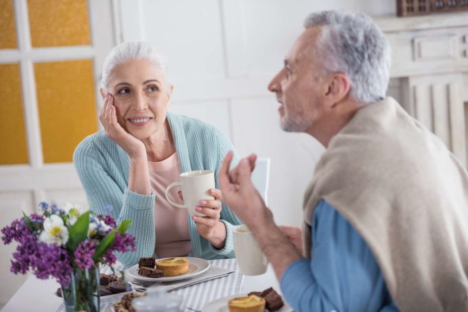 Coppia senior a colazione chiacchierando